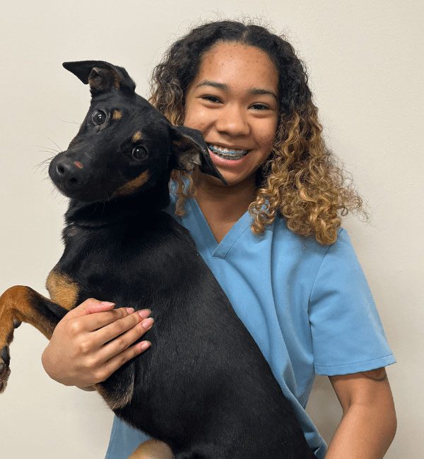 Brianna holding up a black and brown dog
